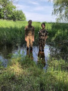 Two humans standing in a swamp